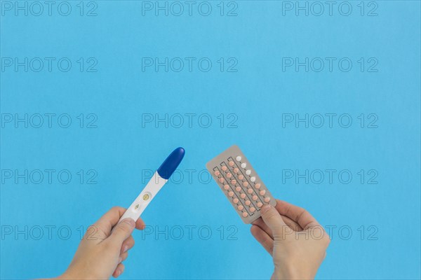Hand holding contraceptive pills pregnancy test