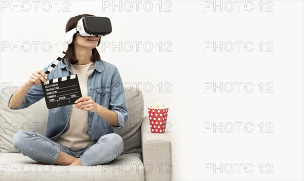 Portrait woman with virtual reality headset eating popcorn