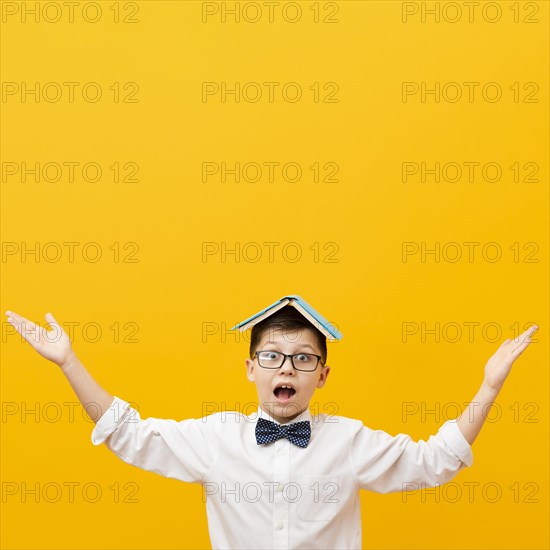 Playful boy with book head