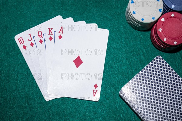 Royal flush playing cards with casino chips poker table