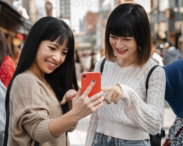 Pretty asian girls together outdoors