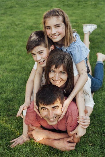 Portrait happy family laying grass park