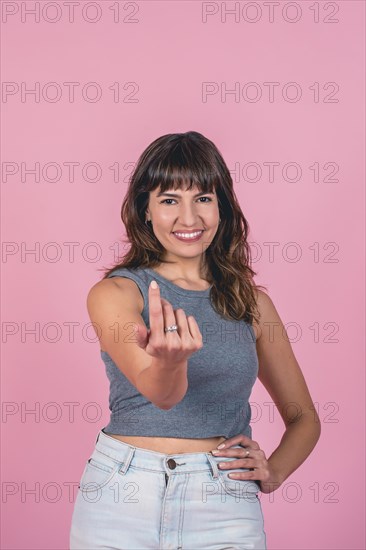 Studio portrait of a woman calling with one finger