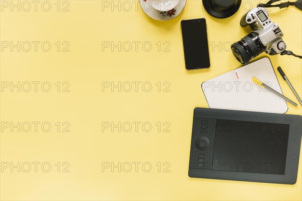 Digital graphic tablet camera cellphone with stationery yellow background