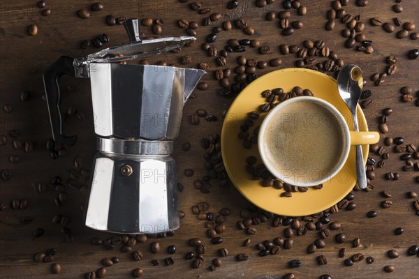 Geyser coffee maker near yellow cup with spoon plate