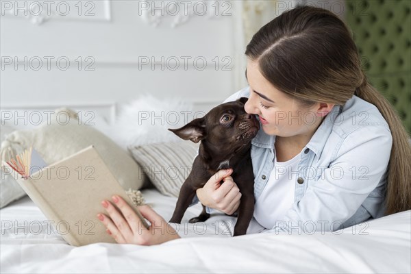 Close up girl reading bed with cute dog