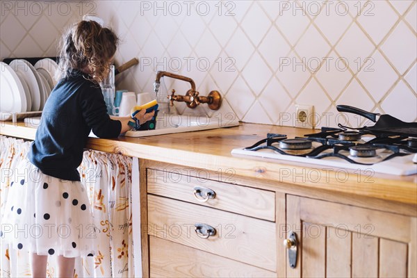 Girl washing cup kitchen sink