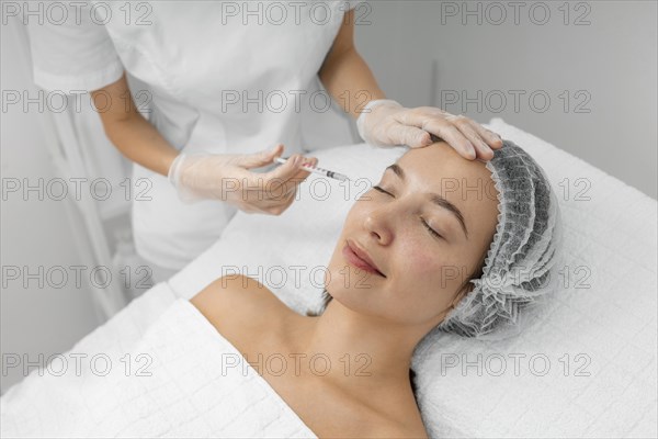 Beautician doing injection filler female client salon