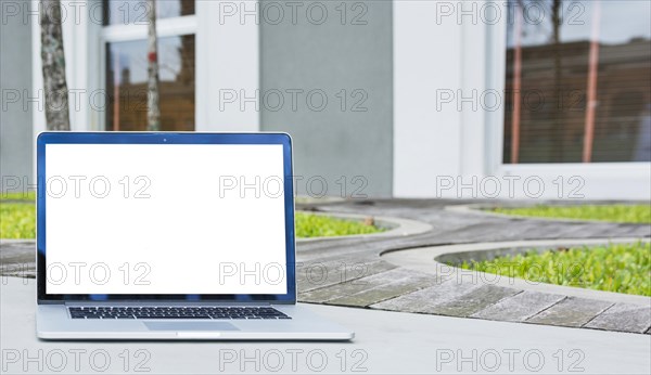 Laptop with blank screen front house