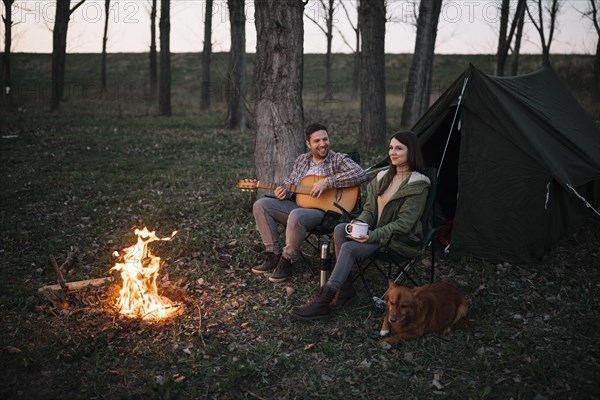 Full shot couple playing guitar