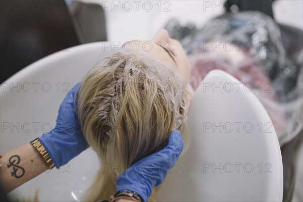 Stylist washing off dye sink