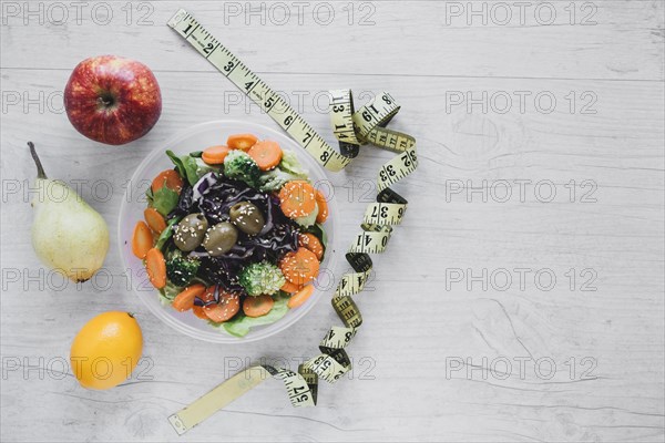 Measuring tape near salad fruits