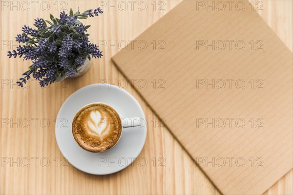 Coffee latte with lavender flower notebook wooden background