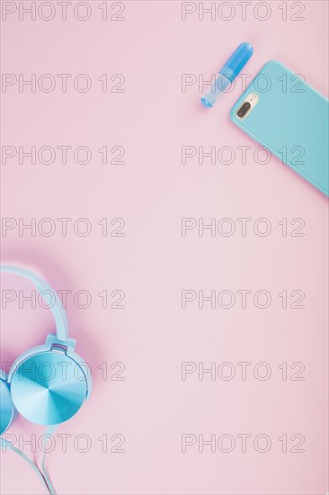 Elevated view headphone smartphone pink background