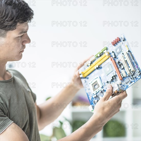Young man looking motherboard circuit