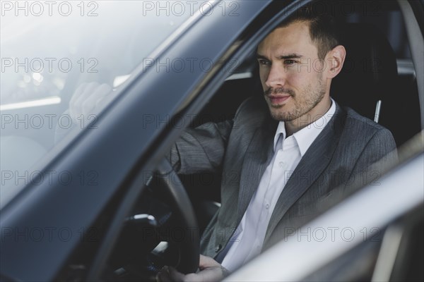Close up young handsome businessman sitting car seat