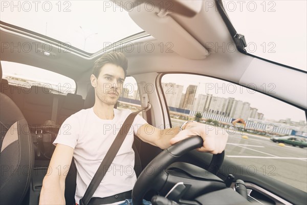 Portrait handsome young man driving car