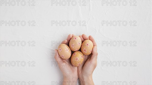 Top view hands holding decorated easter eggs