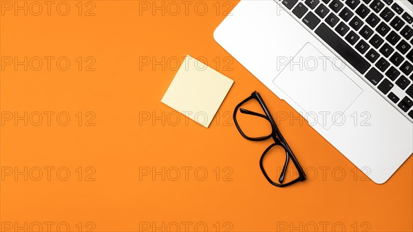 Top view desk concept with orange background
