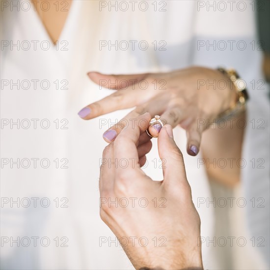 Man s hand putting engagement ring his girlfriend finger