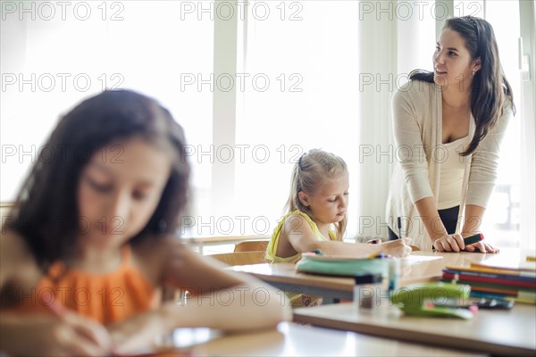 Female teacher leaning upon table looking away