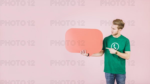 Man pointing empty orange speech bubble pink backdrop