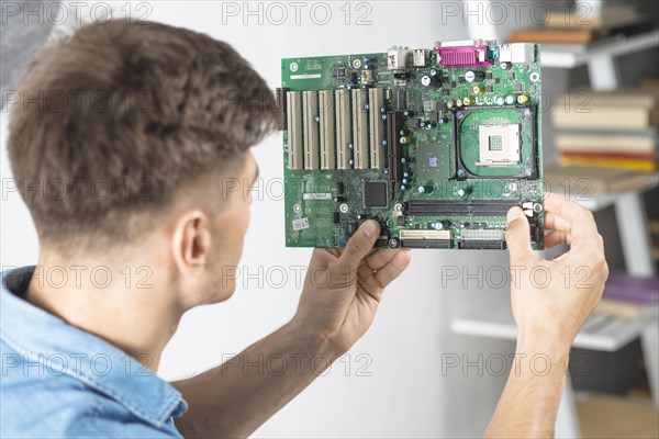 Young it technician looking motherboard