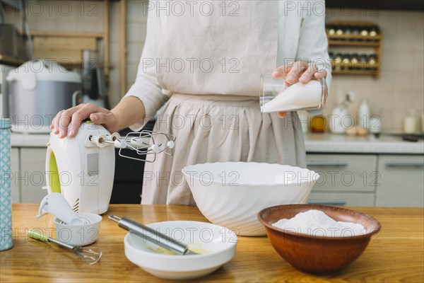 Female chef preparing pie kitchen with ingredients table