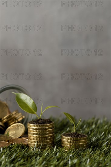 Front view two stacks coins grass with jar copy space
