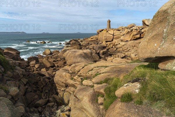 The rocks of the pink granite coast Cote de Granit Rose and the lighthouse Phare de Ploumanac'h near Ploumanac'h