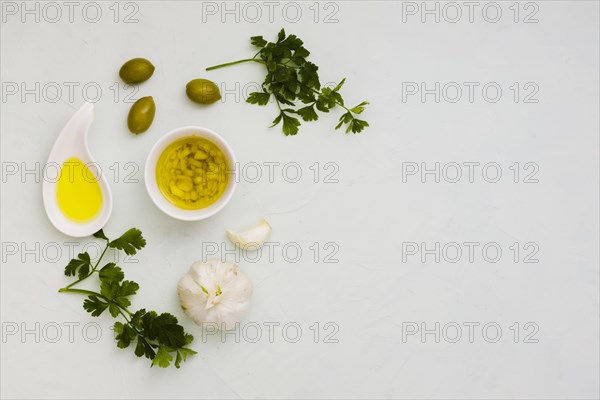 Garlic infused olive with olives parsley leaves white background