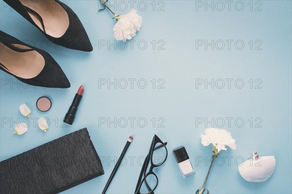 White flowers with cosmetics woman shoes table
