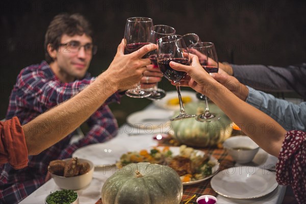 People clinking glasses table