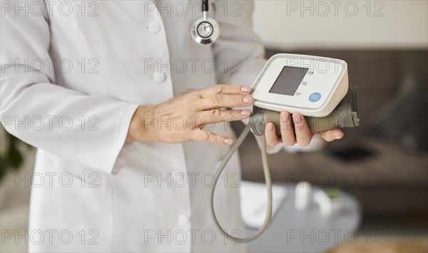 Elder covid recovery center female doctor holding blood pressure monitor