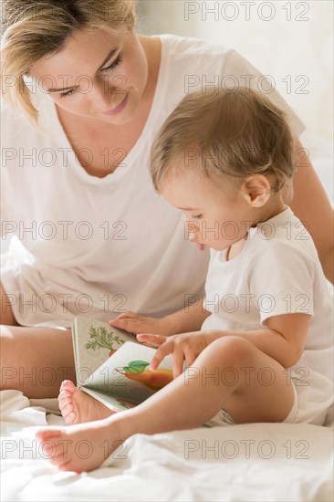 Portrait mom reading baby bed