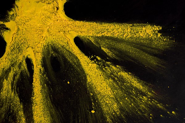 Yellow powder color exploding black backdrop