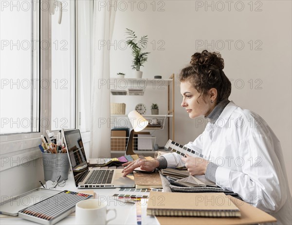 Medium shot woman working with laptop