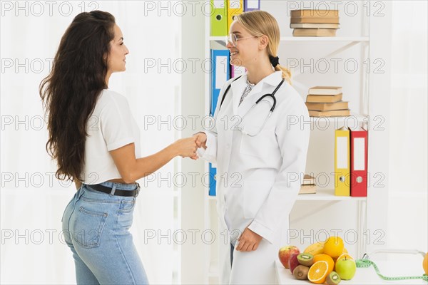Side view doctor patient shaking hands