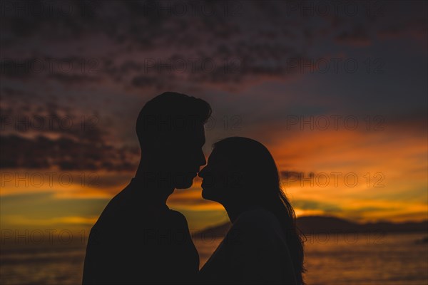 Young couple standing sea shore night