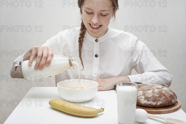 Cute girl pouring milk bowl