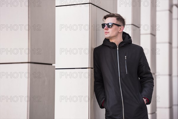 Young man with hands his pocket looking away