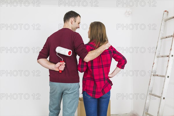 Back view couple looking painted wall