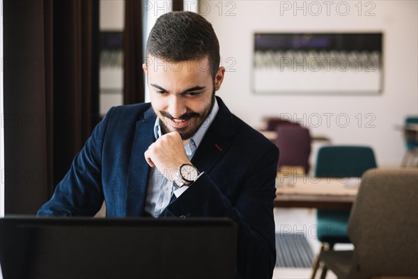 Cheerful elegant man using laptop