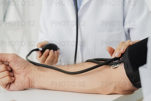 Close up doctor inflating blood pressure cuff