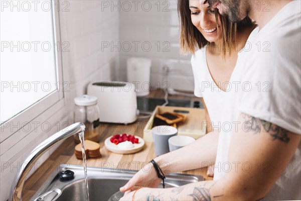 Couple washing dishes together