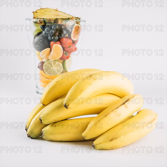 Bananas near glass with fruits