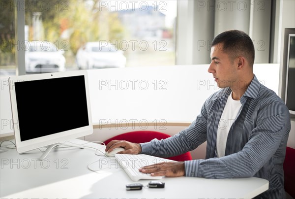 Young car dealer working office