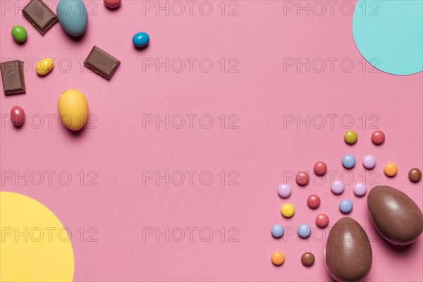 Chocolate easter eggs gem candies with copy space writing text pink background_2