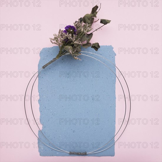 Empty decorative frame made with metallic cable flower bouquet paper pink background