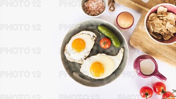 Fried omelette with tomato cucumber plate white background